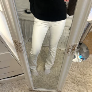 Vita bootcut jeans från Lee - Säljer ett par snygga vita jeans från Lee med bootcut passform. Byxorna har klassiska fem fickor, dragkedja och knapp framtill samt Lee-logga på bakfickan. Perfekta om du vill ha ett fräscht och stilrent plagg i garderoben. Använd en gång. Dessa byxor har inte dom vanliga storlekarna men passar mig som är en xs/s och är ca 163 men den är exakta storleken ser du på en av bilderna. 