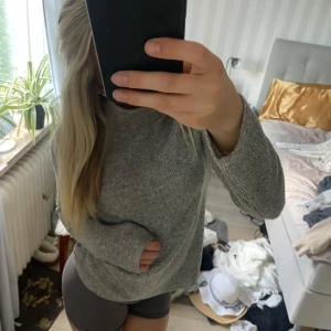 Grå stickad tröja  - Mysig grå stickad tröja med avslappnad passform. Perfekt för kyliga dagar och enkel att matcha med både jeans och tights. Tröjan är typ polo och går upp som en krage. Den är superbekväm att bära. Kommer ifrån Amisu och är i storlek XS