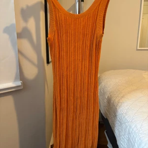 Ribbad orange klänning & Other Stories - Snygg ribbad långklänning från & Other Stories. Första bilden är framsida och andra är bak bara för att vara övertydlig. Runt 1000kr nypris