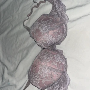 Ljuslila spets-bh med blommönster 70A - Supersöt ljuslila bh med blommig spets och tunna axelband. Bh:n har vadderade kupor och fina spetsdetaljer längs kanterna. Materialet är mjukt och stretchigt för extra komfort. Perfekt för dig som gillar romantiska och feminina underkläder.