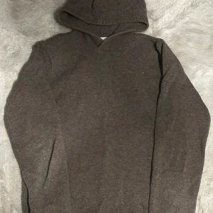 Brun hoodie i merinoull från Vailent XS - Mysig brun hoodie från Vailent i mjuk merinoull. Tröjan har lång ärm, huva och en enkel, stilren design utan tryck eller mönster. Perfekt för dig som gillar en clean look och vill ha något varmt och skönt till kyliga dagar.