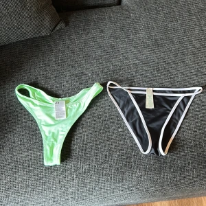Två bikiniunderdelar från H&M och Eco - Säljer två snygga bikiniunderdelar! En i ljusgrönt från H&M med klassisk trosa-modell och en svart med vita kanter från Eco, båda i stretchigt och bekvämt material. Perfekta för stranden eller poolen i sommar.