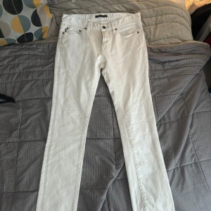 Vita jeans från John Varvatos - Vita jeans från John Varvatos i straight fit. En lite fläck (bild 3) syns knappt och går säkert att få bort med rätt medel. Storlek 31, motsvarar W28L32.