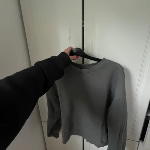Grå basic sweatshirt i bomull - Enkel och stilren grå sweatshirt med rund hals och långa ärmar. Tröjan är i mjuk bomull och har en loose passform, perfekt för en chill och avslappnad look. Passar till allt och är ett måste i garderoben.