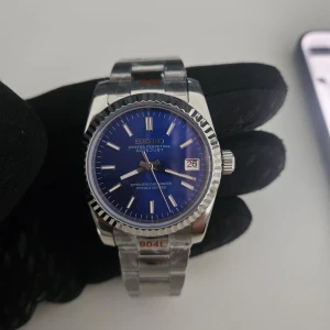 Seiko mod Datejust blå urtavla stål - Klassisk Seiko Datejust med blå urtavla och datumvisning. Klockan har en rund boett och länkarmband i rostfritt stål med räfflad bezel. Snygg och stilren design med tydliga index och silverfärgade visare. Perfekt accessoar för dig som gillar tidlös stil.