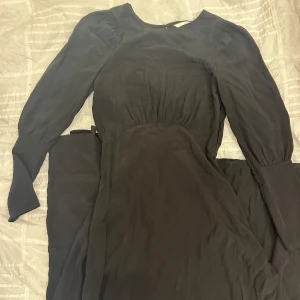 Svart finklänning - Jättesöt svart finklänning från H&M med öppen rygg. Ger en fin siluett. Säljs då den inte används.