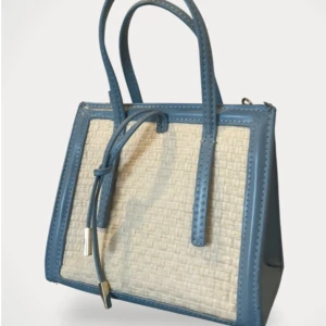 Blå och flätad handväska från Zara - Snygg handväska från Zara i ljusblått syntetmaterial med beige flätad front. Väskan har både handtag och en lång guldfärgad kedja för axeln. Stilren och boxig form, perfekt för att lyfta din outfit.