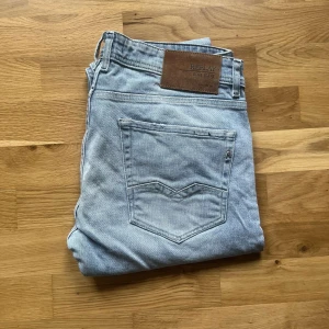 Replay jeans  - Säljer ett par ljusblå jeans från Replay, modell ROC CO Comfort Fit. Klassisk femficksdesign, raka ben och snyggt Replay-läderpatch bak. Jeansen är i mjuk bomullsdenim och har en avslappnad passform som funkar till allt. Längd 98