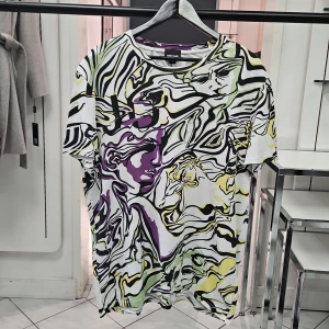 Just Cavalli t-shirt med abstrakt mönster - Snygg t-shirt från Just Cavalli i storlek L med ett unikt abstrakt mönster i svart, vitt, gult, grönt och lila. T-shirten har korta ärmar och är tillverkad i mjuk bomull. Perfekt för dig som gillar statement-plagg och vill sticka ut med cool design.