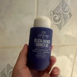 Sol de Janeiro Delicia Drench Shower Oil - En lyxig duscholja från Sol de Janeiro i en snygg lila flaska med vit kork. Innehåller 90 ml och har doften Cheirosa 59. Oljan är djupt återfuktande och innehåller prebiotika och bacuri-smör för extra näring till huden.