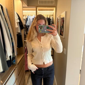 Ribbad beige kofta från Mango - Superfin ribbad kofta från Mango i en ljus beige färg. Modellen är vanlig med långa ärmar och knappar hela vägen framtill. 