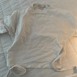 Nelly T-shirt med knyt i ryggen - Säljer min fina Nelly T-shirt i storlek xs! Tröjan är i super fint skick, använd några gånger men inga defekter vad jag kan lägga märke till. Skriv för fler bilder eller tankar!