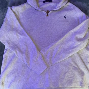 Grå Quarter zip 1/4 Sprillans ny! - PERFEKT FÖR RESELLING!!Snygg grå långärmad tröja från Polo Ralph Lauren med klassisk broderad logga på bröstet. Tröjan har en half zip-dragkedja med läderdetalj och är gjord i mjuk bomull. Perfekt för lager-på-lager och chill stil. Lägg ett dm vid intresse. 