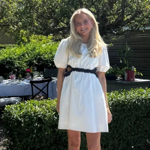 Vit kort klänning med puffärm - Superfin vit kort klänning med puffiga kortärmar och svart detalj i midjan. Klänningen har en luftig passform och är perfekt för varma dagar. Söt och stilren look med rund halsringning och markerad midja. Från Zara barnavdelning men passar mig som är 165 cm och XXS/XS