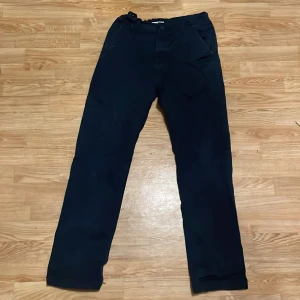 Svarta byxor från Lindex - Snygga mörkblå byxor från Lindex med en klassisk design. Byxorna har en rak passform och är tillverkade i ett bekvämt material. Perfekta för en stilren look.