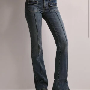 Blå bootcut jeans - OM NI ÄR INTRESSERADE GÅ IN OCH KÖP PÅ MIN VINTED Evelinekarlss. Snygga blå bootcut jeans med låg midja och framträdande fickdetaljer. Perfekta för en avslappnad men stilren look. De har en klassisk femficksdesign och en bekväm passform.