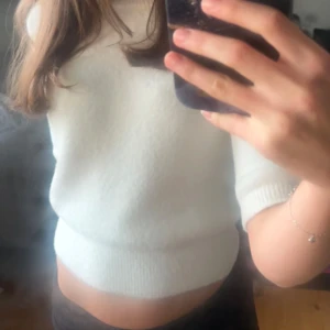 Stickad trekvartärmad tröja från Zara - Säljer en stilren vit stickad tröja från Zara. Tröjan har en croppad passform med trekvartsärmar använd fåtal gånger därav inga defekter och är i storlek S!