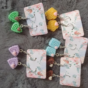 Färgglada örhängen med hjärtan - Säljer ett set med färgglada örhängen i olika former och färger. Varje par har en unik design med små hjärtan i olika färger. Perfekt för att lägga till en lekfull touch till din stil.