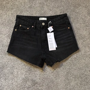 Svarta jeansshorts från Gina tricot  - Snygga svarta jeansshorts från gina tricotmed fransade kanter. De har en klassisk femficksdesign och knappgylf. Perfekta för sommaren. Aldrig använda💕