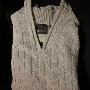 Beige stickad tröja från Oscar Jacobson - Säljer en stilren beige stickad tröja från Oscar Jacobson. Perfekt för kyligare dagar med sin långa ärmar. Aldrig använd men inga tags eller andra tillbehör medföljer. Nypris ligger på 3000kr. Passar S/M