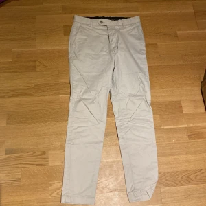 Beige chinos från Bläck - Snygga beige chinos från Bläck. De har en klassisk design med knapp och dragkedja framtill. Perfekta för en stilren look. Storlek 46, knappt använda