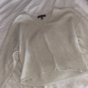 Vit/Beige v-ringad tröja från Vera Moda  - En vit beige stickad tröja från Vera Moda i storlek M. 