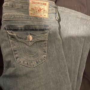 Blå jeans från True Religion - Snygga blå jeans från True Religion med låg midja och flare-stil. De har en klassisk femficksdesign. De är förkortade hos en skräddare, säljer pågrund av att de blev lite för korta för mig. Perfekt till dig som är 152-166