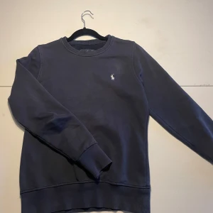 Ralph Lauren Tröja - Säljer en stilren mörkblå sweatshirt från Ralph Lauren med det klassiska vita märket på bröstet. Tröjan är i bra skick och är i storlek Small. Fritt fram att ställa frågor och be om någon mer bild och om priset är dåligt så kom med ett förslag men INGA SKAMBUD! Mvh Viggo