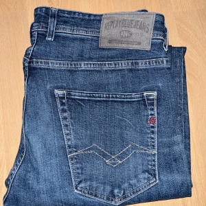 Blå jeans från Replay - Snygga blå jeans från Replay med klassisk femficksdesign och dragkedja. De har en diskret logga på bakfickan och en bekväm passform. Perfekta för en avslappnad stil.