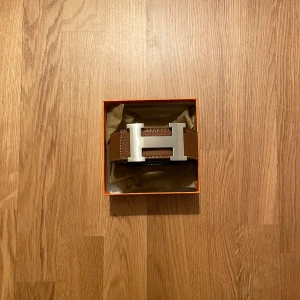 Bälte - Brunt skärp med en H-design, 115 cm! Hör av vid minsta fundering och för mer information!