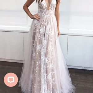 Vit spetsklänning med blommönster - Fin balklänning i vit spets med blommönster och djup v-ringning. Underkjolen är i färgen rosa/ beige. Helt oanvänd, bara testad 💞stl 38 😊 skriv för fler bilder, priset går att diskuteras!