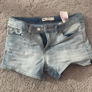 Ljusblå lågmidjade jeansshorts - Säljer ett par ljusblå jeansshorts från Levi's. Perfekta på sommarn. Levi's logga syns på baksidan. Aldrig använda