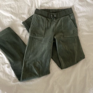 Gröna mjukisbyxor från Juicy Couture - Juciy Couture byxor i storlek Xs, använda och små slitningar därav priset. Ena metall-detaljen har försvunnit på ena snöret se på bild 5, och ett liten hål på högra knät se på bild 4. Hoppas dom kan hitta en ny ägare som kan älska dom lika mycket som jag har gjort!💞pris kan diskuteras!