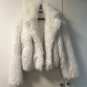 Vit pälsjacka från Gina Tricot - Säljer en fluffig och stilren vit pälsjacka från Gina Tricot. Jackan långa ärmar och en enkel design.