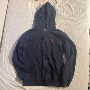 Us Polo ASSN zip hoodie - Blå zip hoodie från märket US POLO ASSN. Storlek 14-15 år, 8/10 skick bara lite skrynklig. Tveka inte och skriv om du har frågor, pris kan diskuteras!