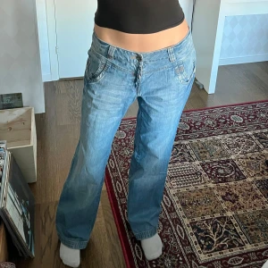 Lågmidjade baggy jeans - Lågmidjade baggy / vida jeans från Lindex. Midjemått: 84 cm, 42 cm mätt platt. Innerbenslängd: 80 cm. Jag är 176 cm för referens. Storlek 44, men passar mer en 40
