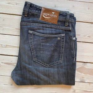 Jeans från Jacob Cohën - Säljer ett par snygga jeans från Jacob Cohën i en mörkgrå tvätt. De är handgjorda med utvalda japanska tyger och italienskt hantverk. Jeansen har en knappgylf och en klassisk femficksdesign. Limited edition, nummer 179 av 262.