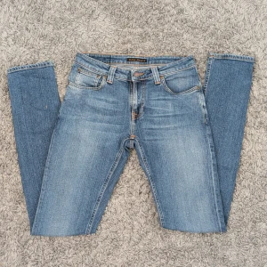 Blå jeans från Nudie Jeans - Snygga blå jeans från Nudie Jeans med en snygg tvätt. De har en slim passform och är tillverkade i högkvalitativt denim. Jeansen är i bra-skick.