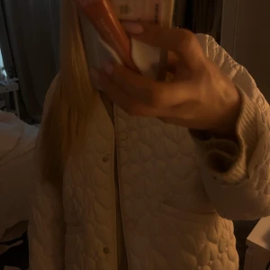 Vit quiltad jacka från Zara - Säljer en stilren vit quiltad jacka från Zara. Jackan har en normal passform med långa ärmar och knappar framtill. Perfekt för att hålla sig varm och trendig under kyligare dagar.