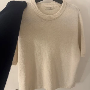 Vit stickad tröja från Gina Tricot - Säljer en stilren vit stickad tröja från Gina Tricot i premiumkvalitet. Tröjan har en rund halsringning och ribbade kanter. Perfekt för en mysig och avslappnad look.