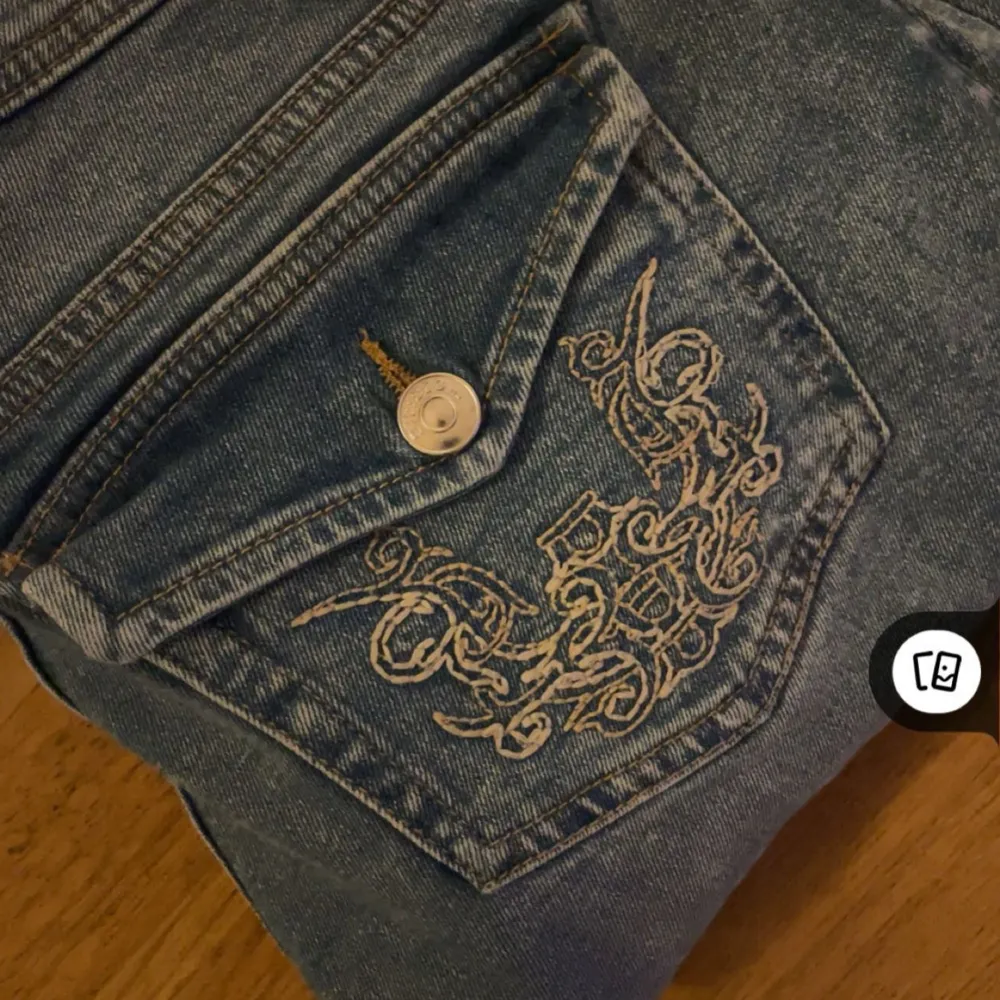 Snygga lågmidjade blå jeans med en broderad design på bakfickan. Lite långa i benen på mig som är 163 så de passar nog perfekt på någon som är runt 165-168!. Farkut & Housut.