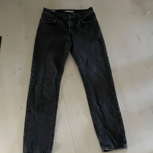 Svarta jeans från Levi's - Snygga svarta jeans från Levi's i modellen Middy Straight. De har en klassisk femficksdesign och en rak passform som ger en tidlös look. Perfekta för dig som gillar en stilren och enkel stil. 🖤