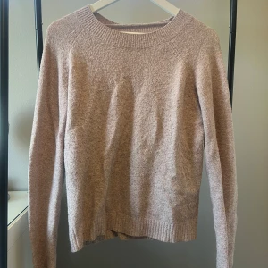 Beige stickad tröja med rund hals - Mysig beige stickad tröja med rundad hals och långa ärmar. 