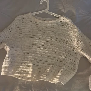 Vit stickad tröja från MNG - Säljer en vit stickad tröja från MNG i storlek M. Tröjan har ett snyggt hålmönster och rund halsringning med ribbad kant. Perfekt för lager-på-lager och chill stil. Passar dig som gillar en enkel men trendig look.