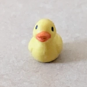 Mini plast anka - En mini gul plast anka med orange näbb. Den är söt och passar som dekoration eller leksak.