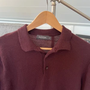 Vinröd polotröja i merinoull Dressmann - Snygg vinröd polotröja från Dressmann i mjuk merinoull. Knappt använd.     Nypris: 899kr 