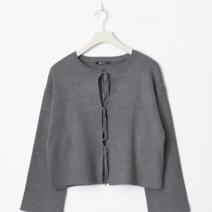 Grå kofta med knytning - Grå kofta från Gina Tricot med snygg snörning framtill. Modellen har lång ärm, rund hals och loose passform. Helt slutsåld. Perfekt att styla över ett linne eller t-shirt för en chill look. Materialet är mjukt och känns skönt mot huden. Kontakta för egna bilder.