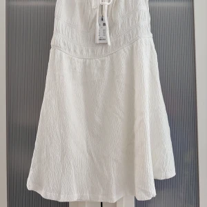 Ny oanvänd Vit kort klänning med knyt - Jätte fin vit klänning. Klänningen har även tyg på nedre delen vilket är mer bekvämt eftersom den inte är genomskinlig. Passar till allt