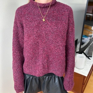 Röd lila stickad tröja  - Säljer en mysig mörklila stickad tröja med lång ärm och loose passform. Tröjan står att den är i medium men modellen på bilden har storlek xs. Jag skulle säga att tröjan passar XS-M beroende på hur man vill att den ska sitta. Tröjan har en lite högre krage och är tillverkad i ett fluffigt, grovstickat material som är jätte skönt. 