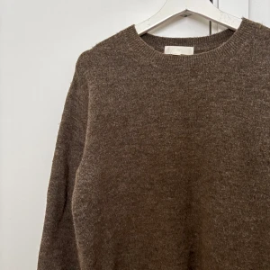 Brun stickad tröja från H&M - Mysig brun stickad tröja från H&M i storlek S. Tröjan har rund hals och långa ärmar, perfekt för kyliga dagar. Materialet känns mjukt och har en klassisk, enkel design som är lätt att matcha med jeans eller kjol. Köpt på Vinted men har inte använt den då jag tycker att färgen inte passar mig